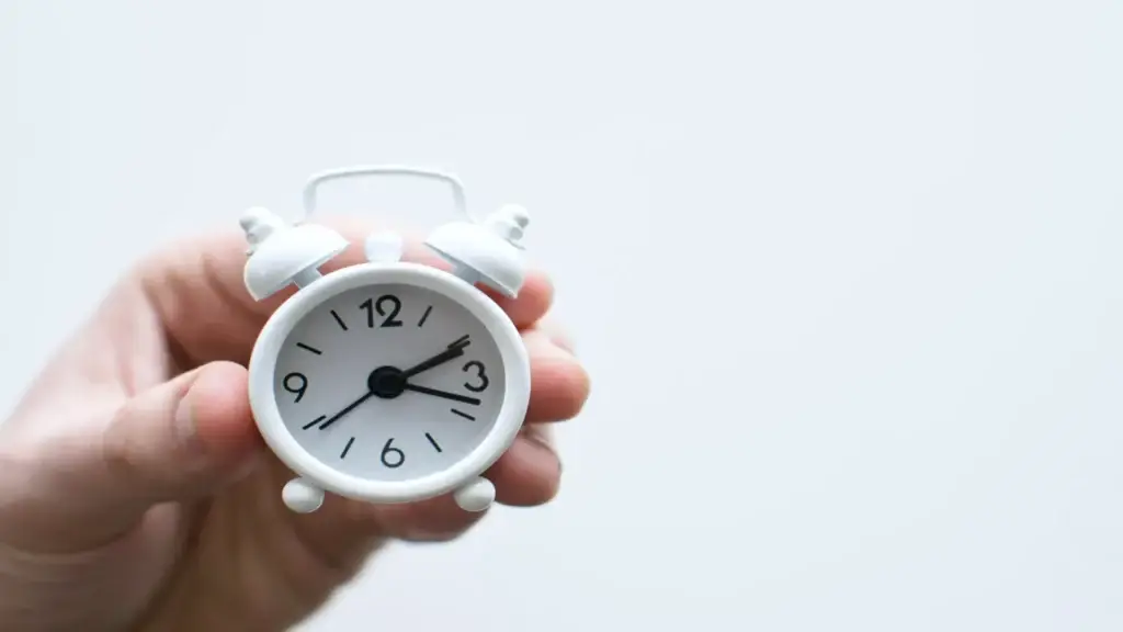 Persona sostenint un rellotge com a símbol del temps dedicat a gestionar una consulta privada